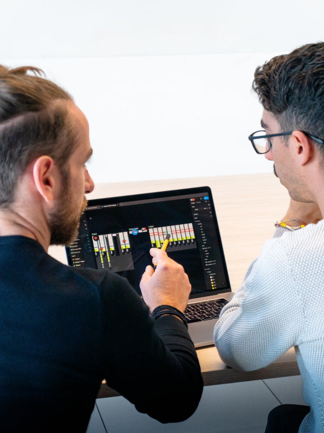 Due uomini guardano uno schermo di laptop che mostra grafici e schemi di dati.