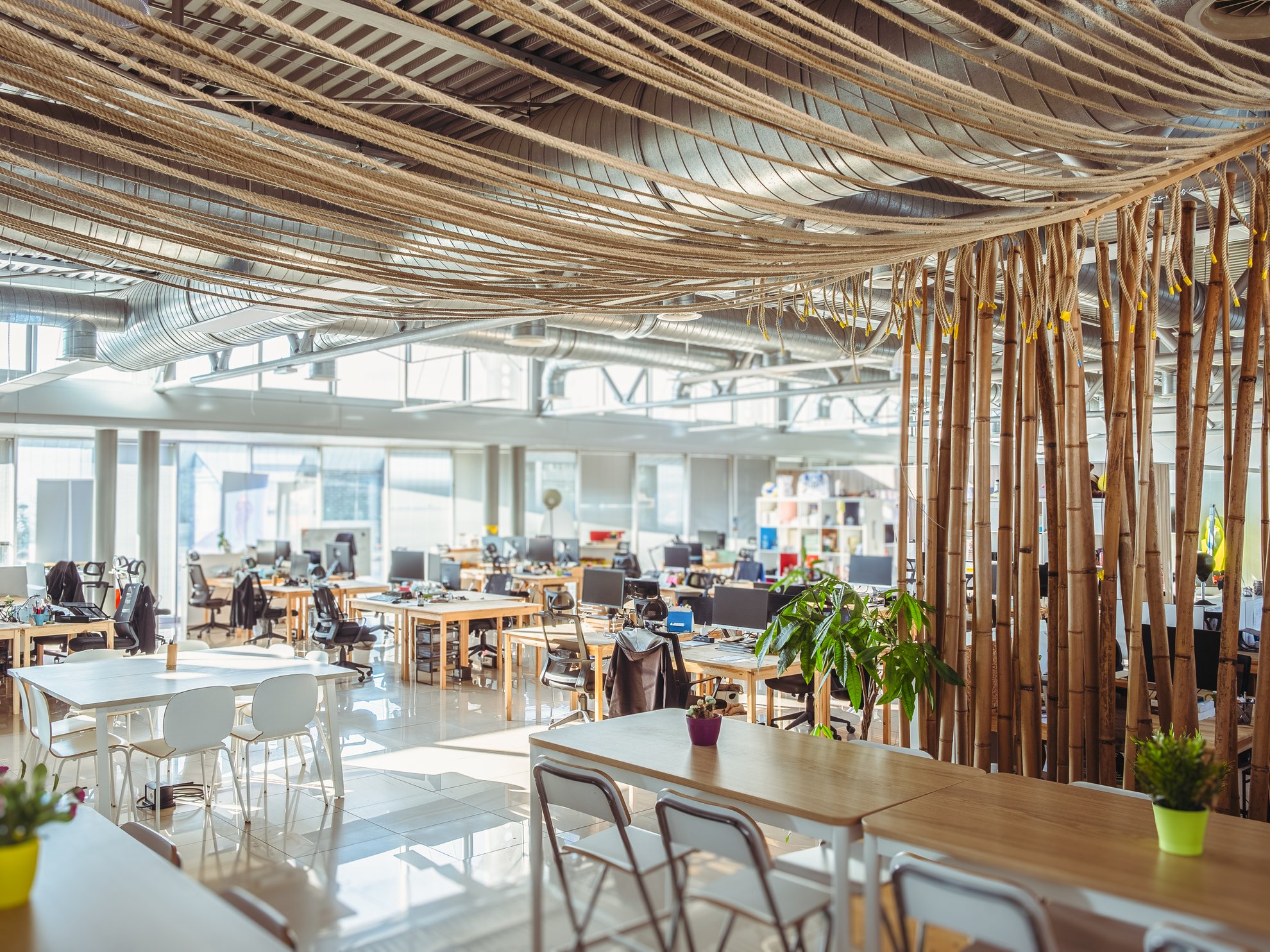 Interno di un ufficio moderno con tavoli e sedie.