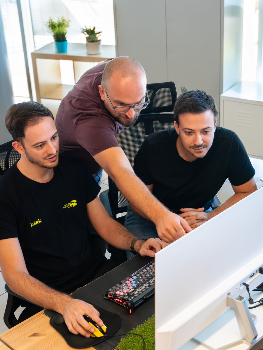 Tre uomini che lavorano insieme al computer