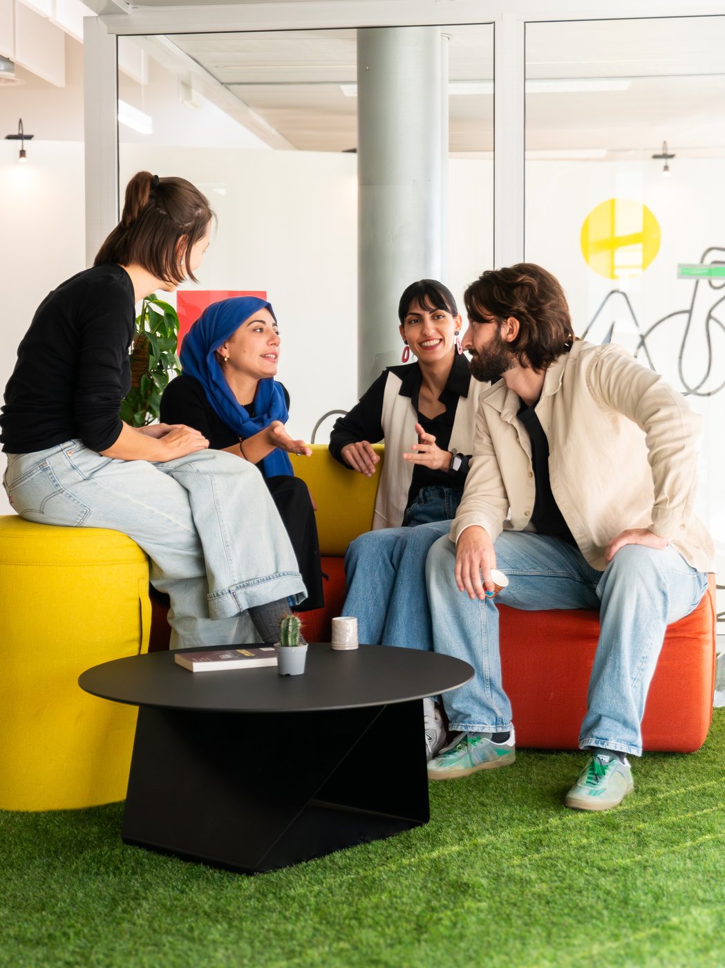 Gruppo di persone che conversano su un divano modulare