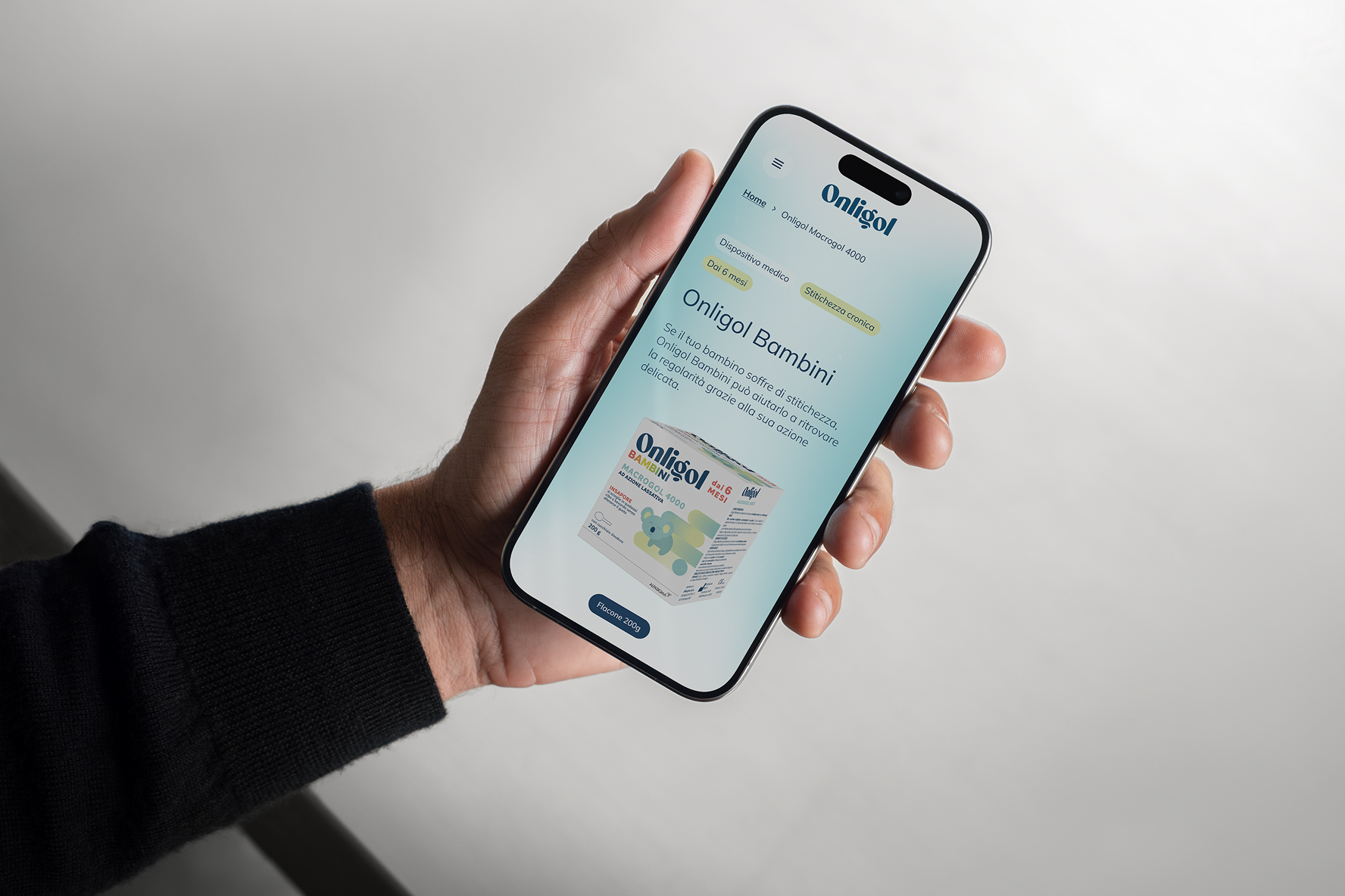 Mano che tiene uno smartphone con visualizzata la pagina web di Onligol Bambini.
