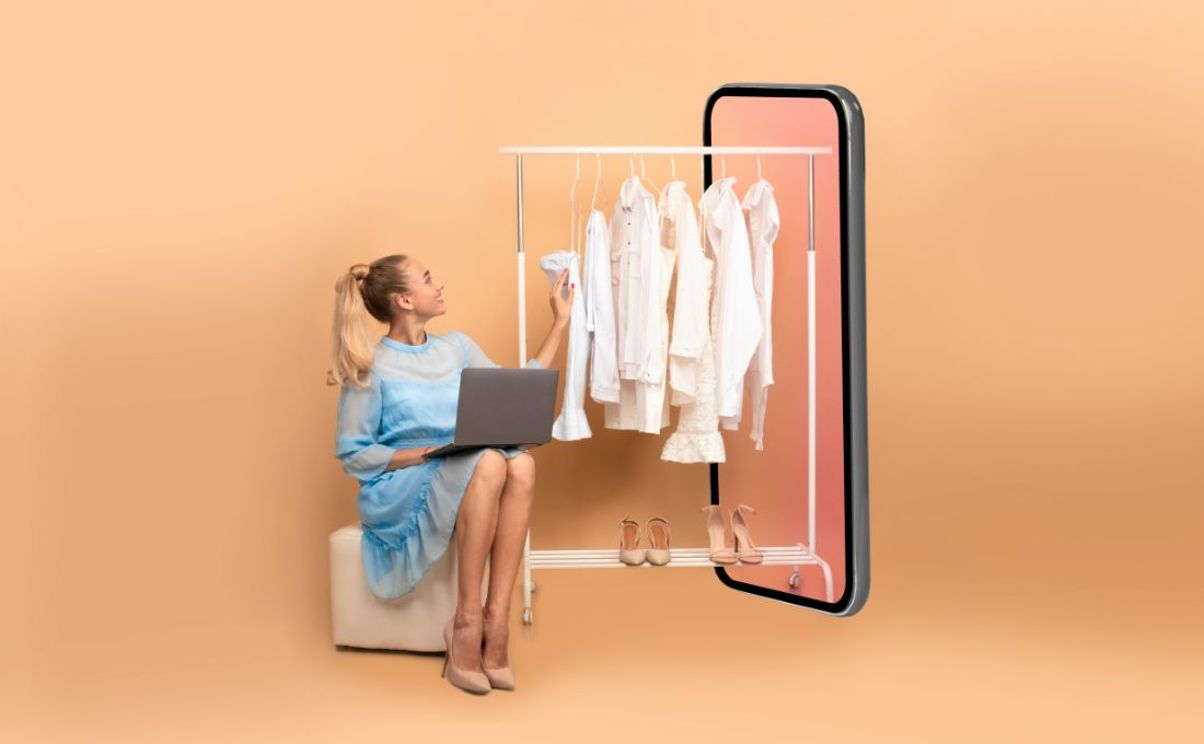 E-commerce nell'eco fashion Ragazza seduta con pc che tocca abiti bianchi